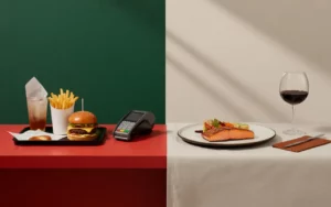 Diptyque photoréaliste 16:9: fast-food à gauche (burger, frites, boisson, TPE neutre) et restaurant traditionnel à droite (saumon, légumes rôtis, verre de vin, calculette), reliés par une tablette 2025 aux graphiques abstraits; Restauration rapide vs traditionnelle : quelles différences comptables ?