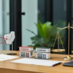 Créer un deuxième établissement : aspects comptables et financiers, illustrés par deux façades de magasin, une balance en laiton, une calculatrice et un graphique minimal sur un bureau en bois éclairé naturellement.