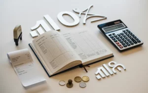 Flat lay photo réaliste sur bureau clair montrant un cahier de comptabilité ouvert (lignes et colonnes illisibles), calculatrice, ticket vierge, assiette avec couverts, terminal de paiement et pièces neutres, illustration de la tva en restauration et des écritures comptables 2026.